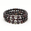 A richly textured sterling silver centerpiece accentuates a handcrafted stretch bracelet with semi-precious Garnet beads.