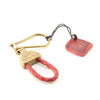 Handmade gold brass keychain with braided leather in red. 