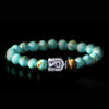 An Egyptian inspired sterling silver centerpiece accentuates a handcrafted stretch bracelet with semi-precious turquoise beads, decorated with a tiger eye bead as a symbol of courage, strength, and power.